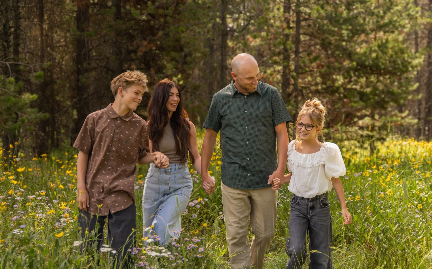 Family of four walking through a wildflower meadow