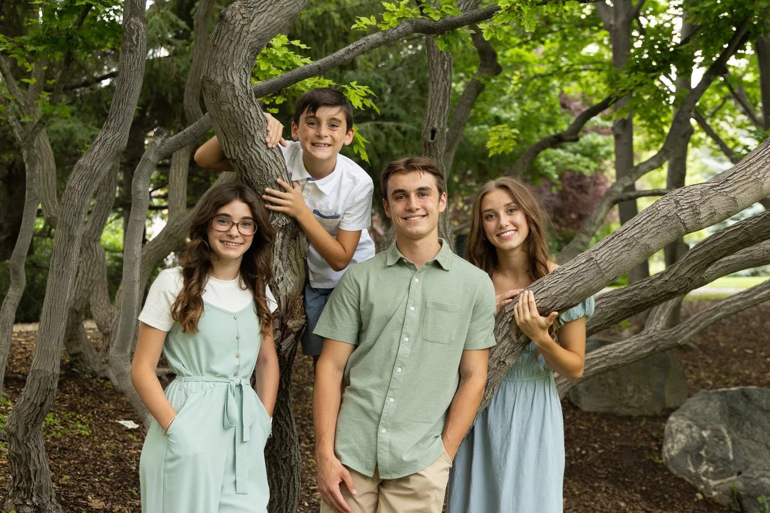 Siblings posing in a twisted old tree