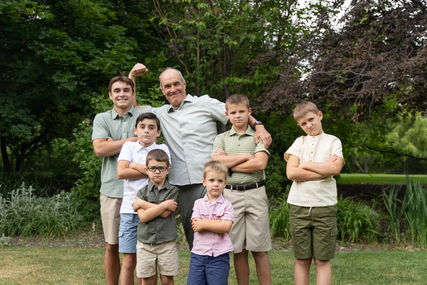 Grandfather posing with his grandsons in a garden