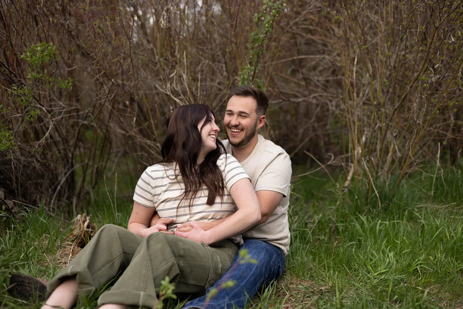 Laughing couple sitting together in the grass
