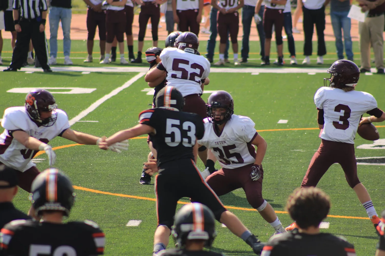 High school football players blocking at the line of scrimmage