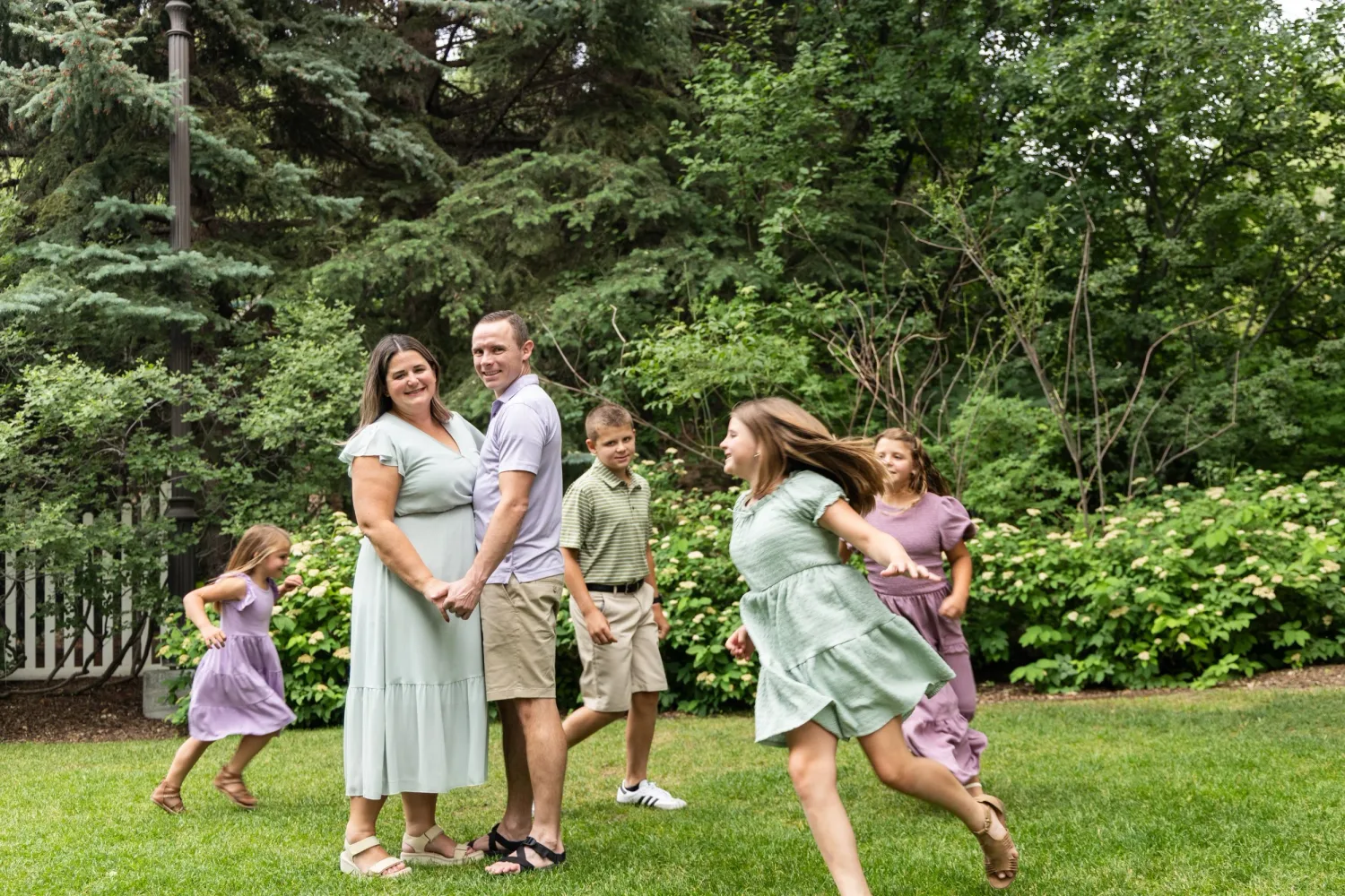 Family playing and twirling on a garden lawn