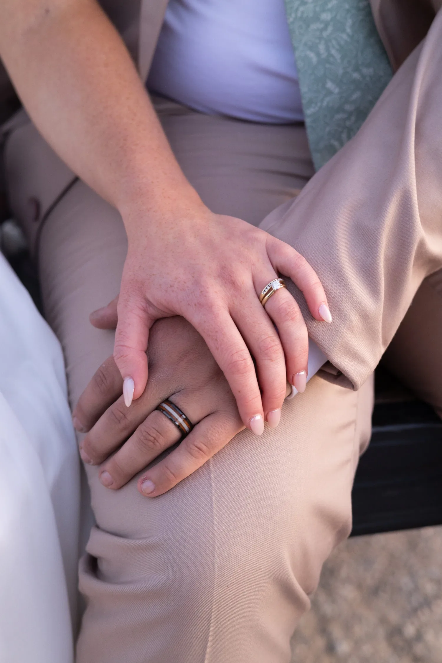 Close-up of the newlyweds' hands showing their wedding rings
