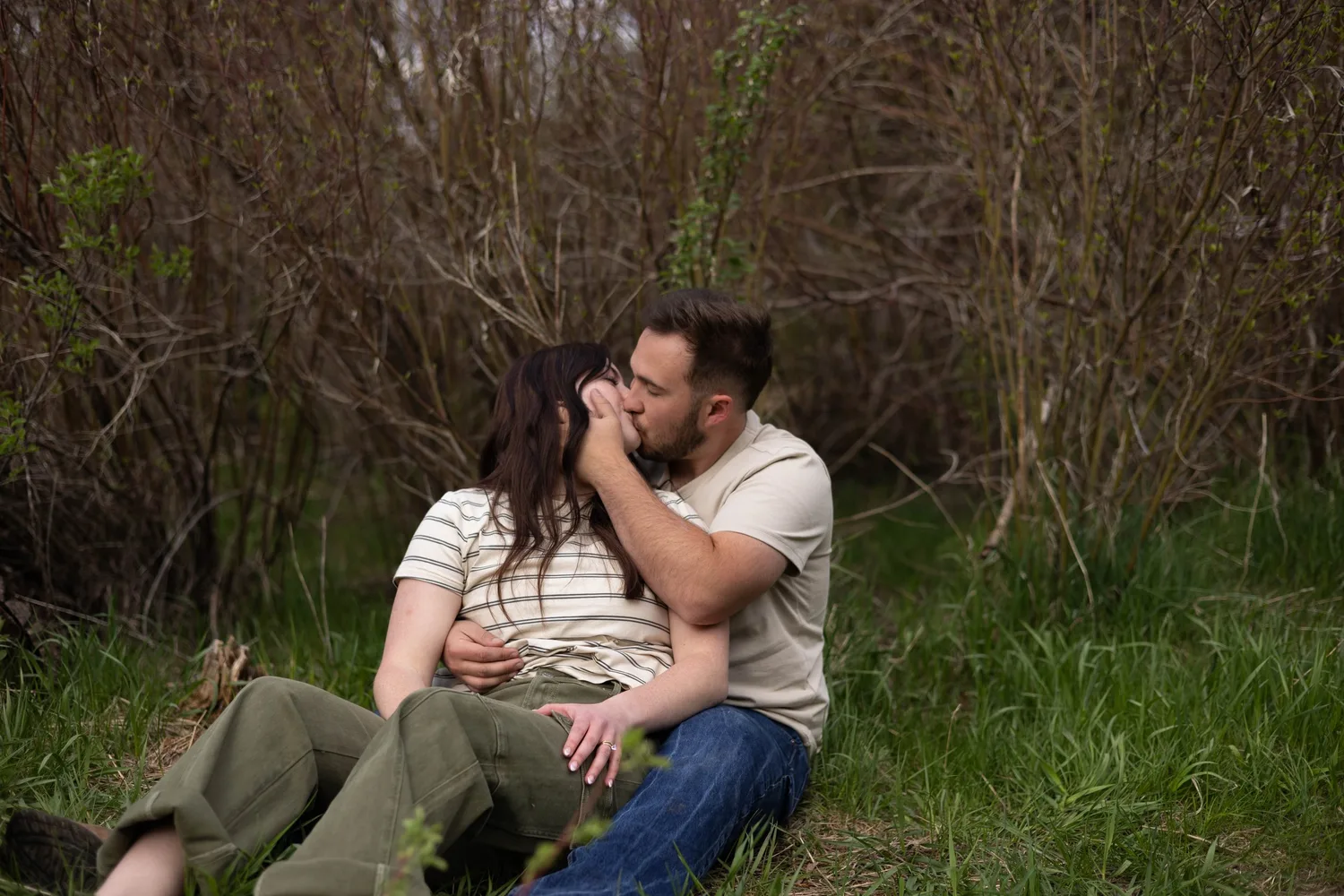 Couple cuddling and kissing in the grass