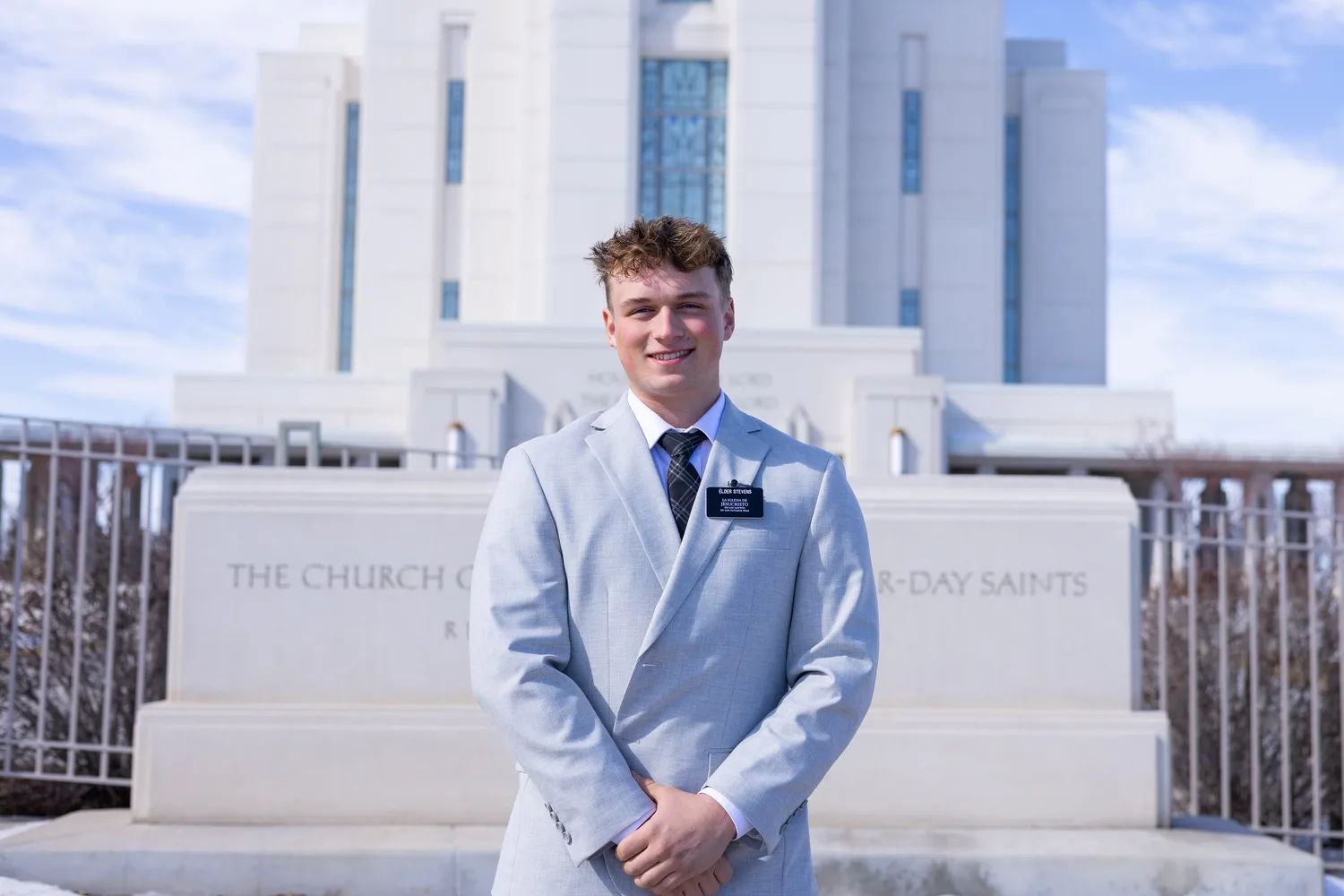Missionary portrait of a young man in a light blue suit in front of the Rexburg Idaho Temple