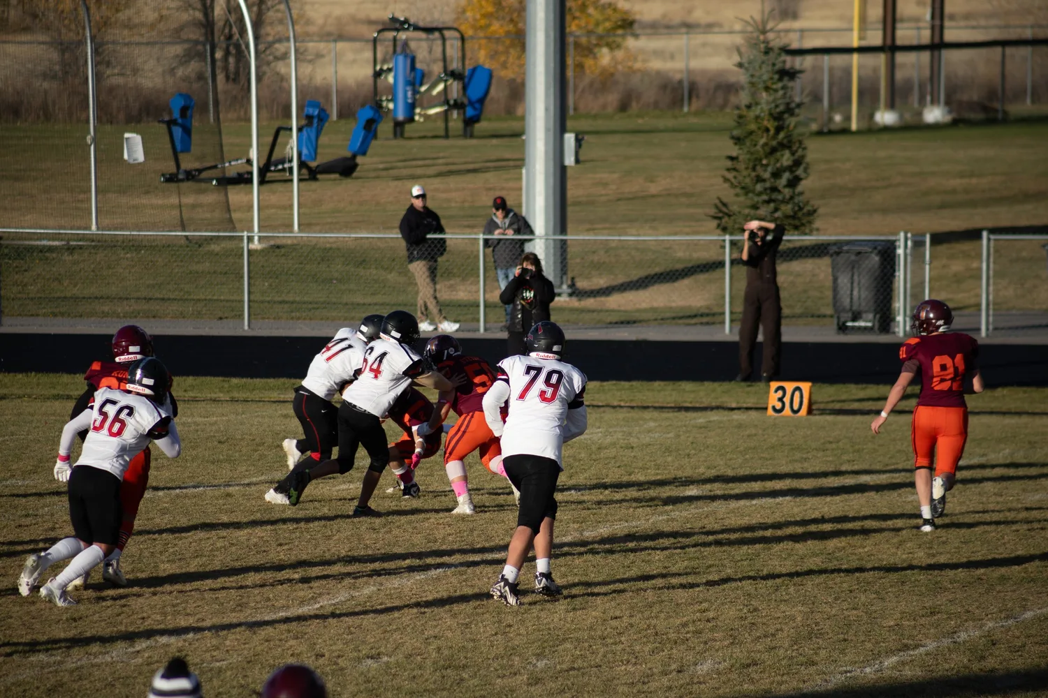 Youth football game in progress on a sunny autumn field