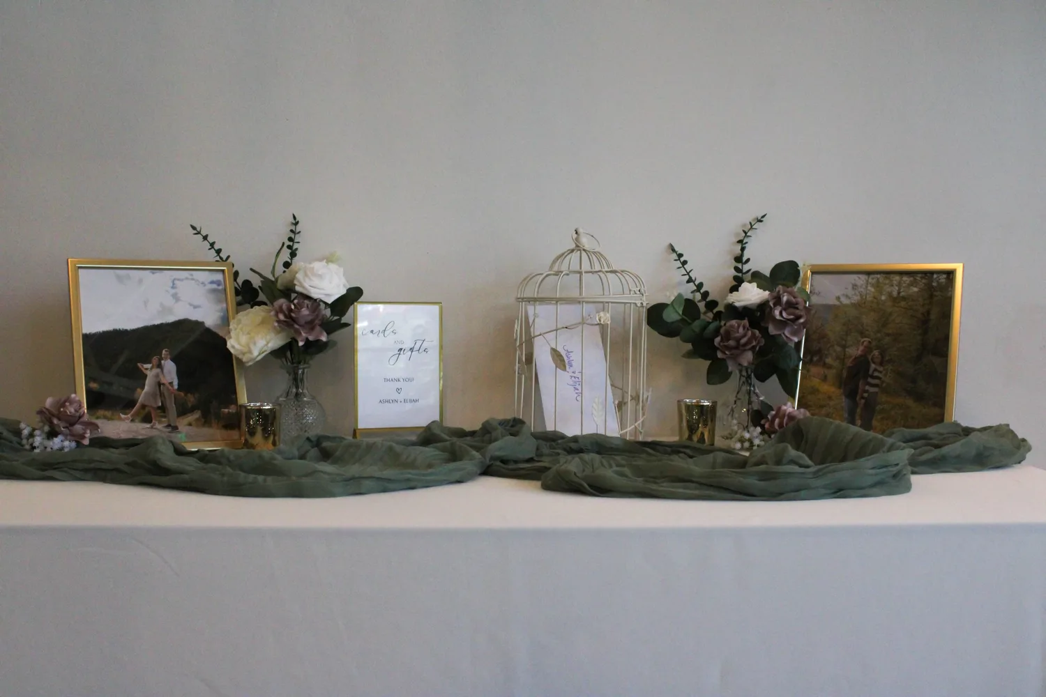 Wedding welcome table with framed engagement photos and dried flower arrangements