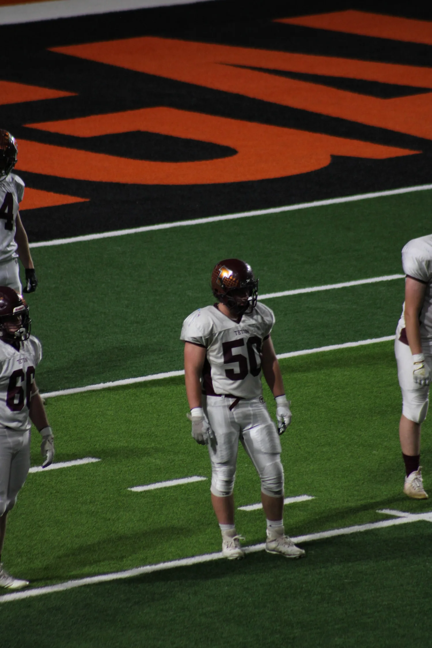 High school football lineman walking back to the huddle