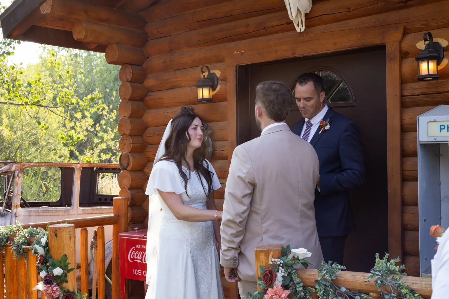 Bride and groom exchanging vows on the porch of a log cabin