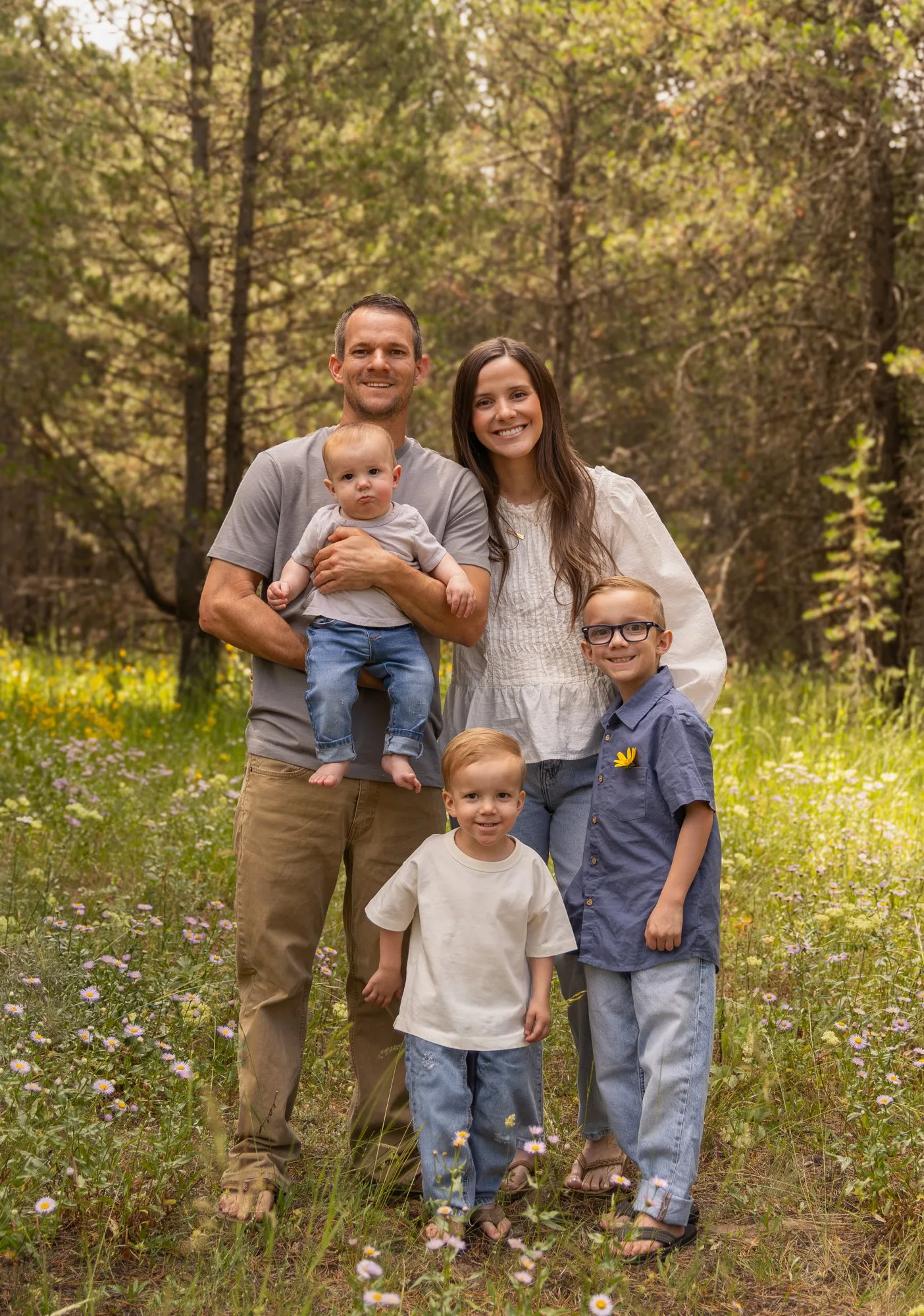 Parents with a baby and two young boys in a forest meadow