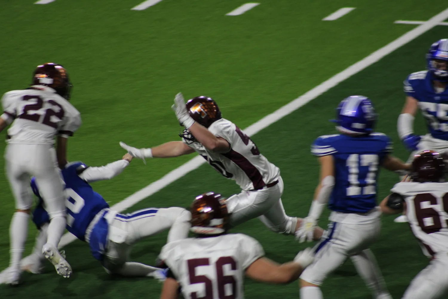 Football players diving for a tackle near the goal line