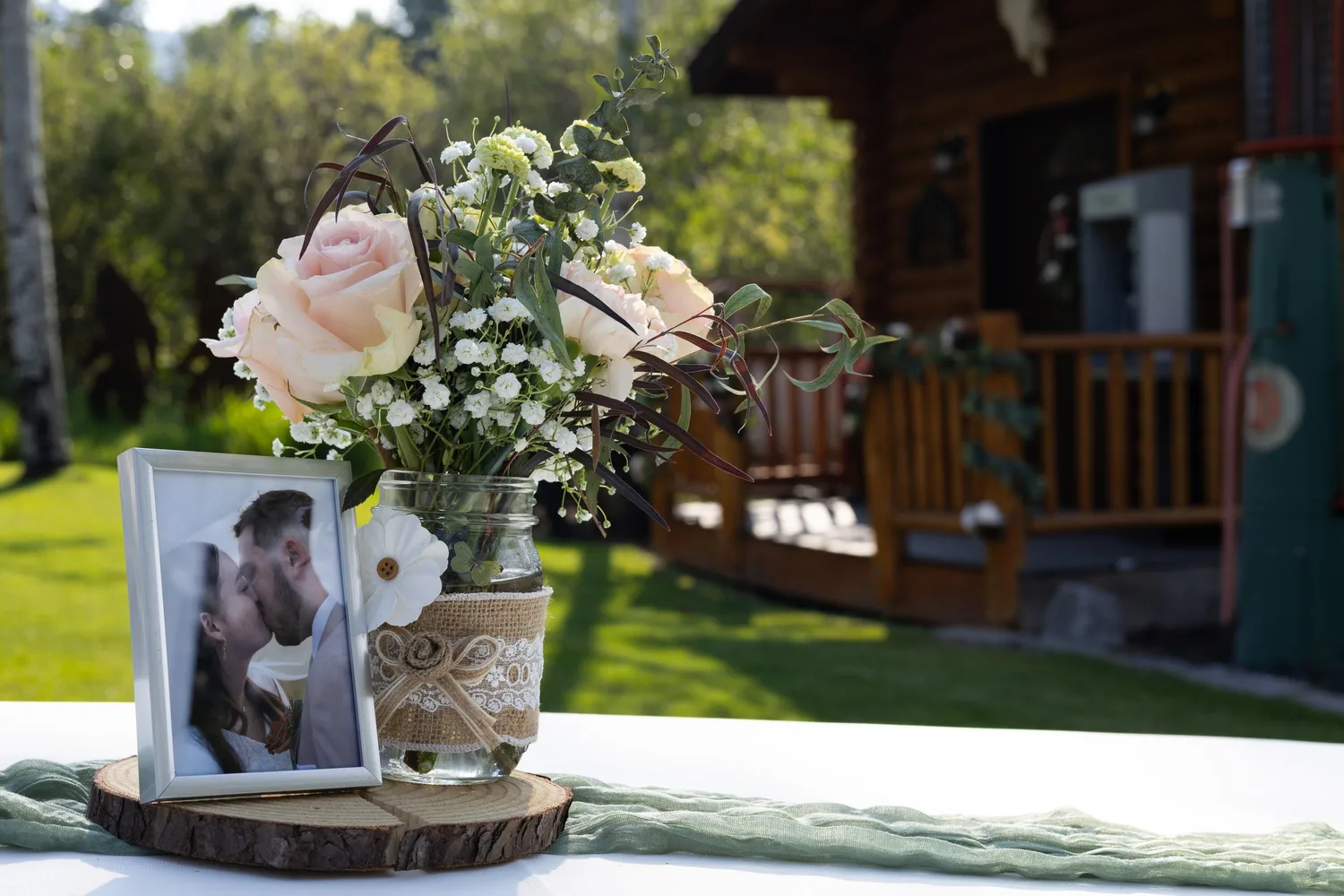 Wedding centerpiece with roses, baby's breath and a framed photo of the couple